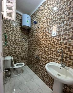 uma casa de banho com um lavatório e um WC em Skylen Hostel em Hurghada