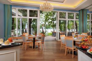 a dining room with tables and chairs and windows at INSELHOTEL Potsdam in Potsdam