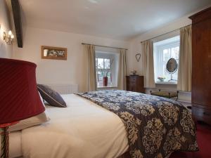 a bedroom with a large bed and two windows at 2 Bed in Cartmel LCC75 in Cartmel