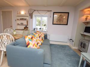 a living room with a blue couch with colorful pillows at 2 Bed in Dunstan CN031 in Craster