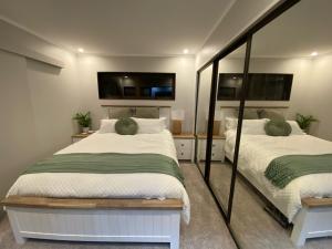 a bedroom with two beds and a mirror at Bluegum Cottage 