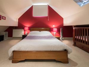 a bedroom with a large bed with a red wall at 2 Bed in Ripon HH082 in Ripon