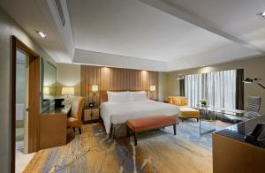 クアラルンプールにあるインターコンチネンタル クアラ ルンプールのベッドとデスクが備わるホテルルームです。