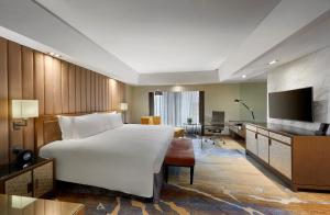 クアラルンプールにあるインターコンチネンタル クアラ ルンプールの大型ベッドとテレビが備わるホテルルームです。