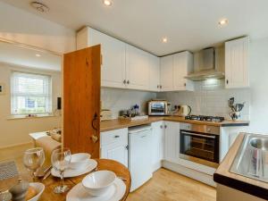 een keuken met witte kasten en een tafel met borden erop bij 1 Bed in Eastbourne EHC45 in Eastbourne