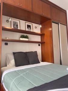 1 dormitorio con 1 cama con paredes y estanterías de madera en Paço de Arcos - Lisboa, en Paço de Arcos