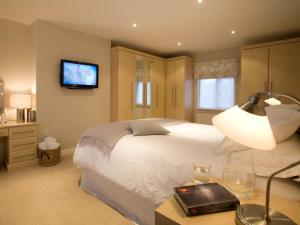 a bedroom with a white bed and a television at 2 Bed in Cartmel LCC47 in Cartmel