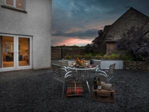 a patio with a table and chairs and a sunset at 2 Bed in Cartmel LCC47 in Cartmel