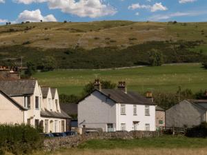 a group of houses with a hill in the background at 2 Bed in Cartmel LCC47 in Cartmel