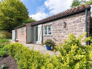 a stone cottage with a door in a garden at 1 Bed in Knaresborough HH102 in Knaresborough