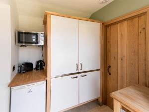 a kitchen with white cabinets and a microwave at 1 Bed in Knaresborough HH102 in Knaresborough