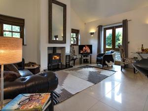 a living room with a leather couch and a fireplace at 1 Bed in Coniston LCC50 in Coniston