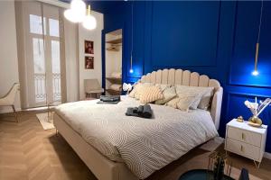 sypialnia z niebieskimi ścianami i dużym łóżkiem w obiekcie Appartamento Belle Époque nel cuore di Torino w Turynie