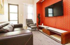 MorningSide Fortyfive في Ongwediva: غرفة معيشة مع أريكة وتلفزيون على الحائط