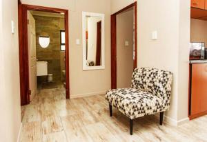 Ongwediva的住宿－MorningSide Fortyfive，一间带椅子的客厅和一间浴室