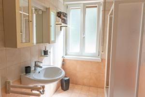 een badkamer met een wastafel en een raam bij Casa Lina in Malcesine