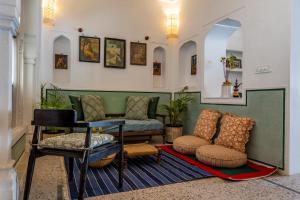 - un salon avec un canapé et une chaise dans l'établissement Sum Jaipur, à Jaipur