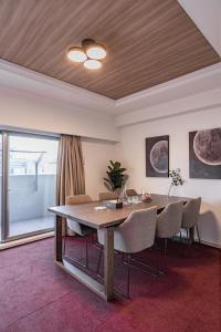 a dining room with a table and chairs at Apartment Hotel 11 Shinsaibashi in Osaka