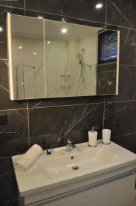 uma casa de banho com um lavatório e um espelho em Dreams Inn Luxury Residences & Lifestyle em Cimenli