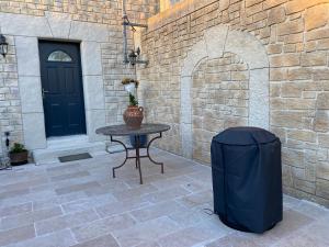 een tafel met een vuilnisbak naast een stenen muur bij Studio Nîmes in Nîmes