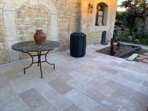 a stone patio with a table and a trash can at Studio Nîmes in Nîmes