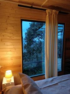 a bedroom with a large window in a log cabin at ANANIA Cottage in Batumi