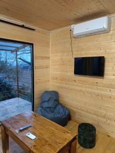 ANANIA Cottage في باتومي: غرفة مع طاولة وتلفزيون وأريكة