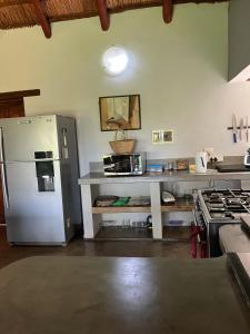 a kitchen with a white refrigerator and a counter at Casa Jardim in Vilanculos