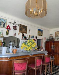 a kitchen with a bar with chairs and flowers at Maison Les Mimosas in Rayol-Canadel-sur-Mer