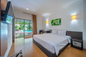 a bedroom with a bed and a flat screen tv at Spazzio Bali Hotel in Legian