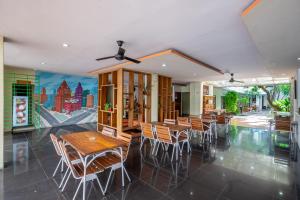 a dining room with tables and chairs and a mural at Spazzio Bali Hotel in Legian