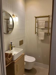a bathroom with a sink and a toilet and a mirror at Maison Baudry Bethune - Bedroom in Béthune