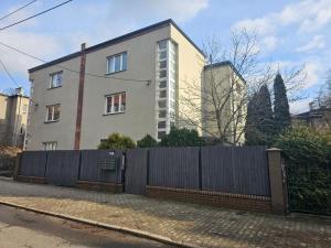 una casa con una recinzione di fronte di URBAN APARTMENTS Studio No 4A Chorzów Katowice, FREE PRIVATE PARKING a Chorzów
