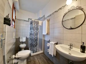 ein Badezimmer mit einem WC, einem Waschbecken und einem Spiegel in der Unterkunft Residenza Cisanello in Pisa