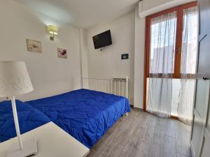 a bedroom with a blue bed and a window at Residenza Cisanello in Pisa