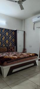 een groot bed in een kamer met een plafond bij PATEL HOME STAY in Garudeshwar