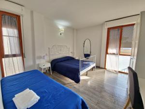 a bedroom with a blue bed and a mirror at Residenza Cisanello in Pisa