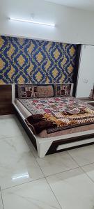 een groot bed in een kamer met een muur bij PATEL HOME STAY in Garudeshwar