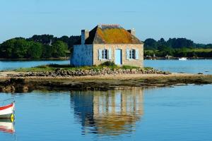 uma casa velha numa ilha na água em Maison au calme, dans le village d'Erdeven em Erdeven