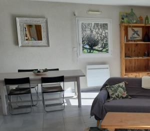 uma sala de estar com um sofá, uma mesa e uma janela em Maison au calme, dans le village d'Erdeven em Erdeven