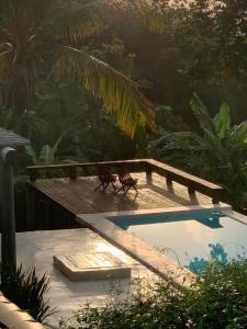 a swimming pool sitting next to a wooden deck at Baleias home in Praia do Forte