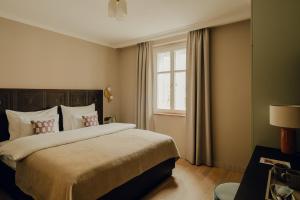 ein Schlafzimmer mit einem großen Bett und einem Fenster in der Unterkunft Hotel Zum Hirschen Salzburg in Salzburg
