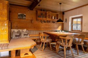 ein Esszimmer mit einer Bank, einem Tisch und Stühlen in der Unterkunft Bauernhaus Untermoos in Breitenbach am Inn