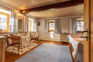 a living room with a table and chairs and a desk at Bauernhaus Untermoos in Breitenbach am Inn