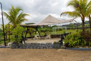 een patio met een tent, een tafel en palmbomen bij Victoria Hills 