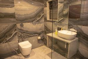 La salle de bains est pourvue de toilettes et d'un lavabo. dans l'établissement White Sand Beach Resort, à Kondivli