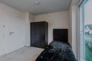 1 dormitorio con cama y ventana grande en EXQUIS Luxus Apartment USM I Kamin I Terrasse I Parkplatz I Mercedes en Böblingen