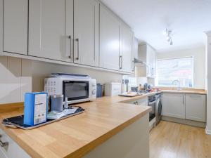a kitchen with white cabinets and a counter with a microwave at 1 Bed in Milford on Sea 79332 in Milford on Sea