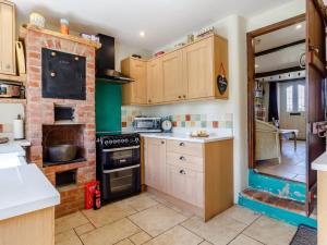 a kitchen with wooden cabinets and a brick wall at 3 Bed in Wroxham 78708 in Honing