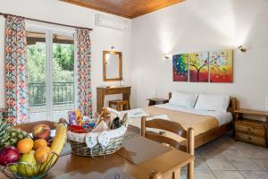 a bedroom with a bed and a table with a basket of fruit at Rania Apartments in Agios Nikitas